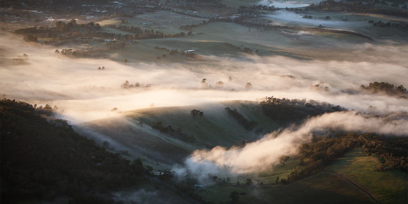 The hills of the Yarra Valley with misty clouds at sunset.